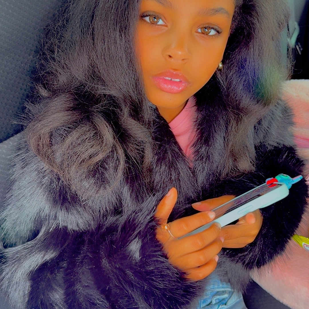 Reya joined the competition — help win amazing prizes! brown_eyes, car_seat, casual_clothing, child, denim_skirt, face, fashion, fur_jacket, girl, hands, indoor, long_hair, looking_at_camera, mobile_phone, phone, pink_tights, portrait, seat_belt, sitting, young_person