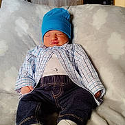 Kain is registered to the contest to win money with this photo: baby, blanket, blue_hat, checkered_shirt, child, clothing, comfortable, cozy, cute, dark_pants, indoors, infant, newborn, peaceful, portrait, resting, sleeping, soft_texture, white_booties, wood_paneling