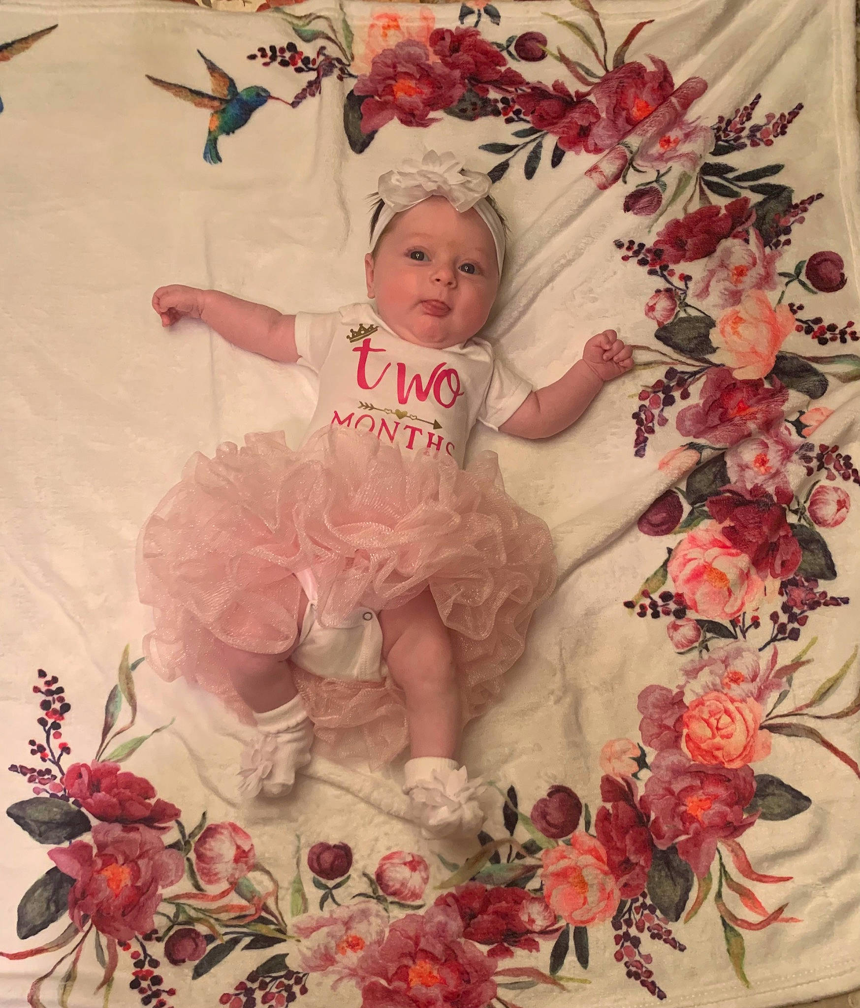 Joanna is registered to the contest to win money with this photo: baby, baby_toddler_clothing, cut_flowers, dress, embellishment, flower, hand, headpiece, linens, magenta, mythical_creature, pattern, peach, person, petal, picture_frame, pink, plant, product, sleeve