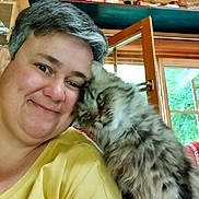 Clochette participe au concours pour gagner de l'argent avec cette photo : person, cat, indoor, smile, face, fur, window, yellow_shirt, hair, cozy, affection, close_up, domestic_animal, pet, happy, friendly, natural_light, wood, greenery, companion
