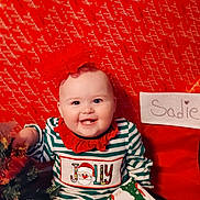 Sadie Dawn is registered to the contest to win money with this photo: baby, child, christmas, cute, decorations, face, festive, gift, happy, headband, holiday, indoor, portrait, present, red_bow, seasonal, smile, striped_clothing, toddler, tree