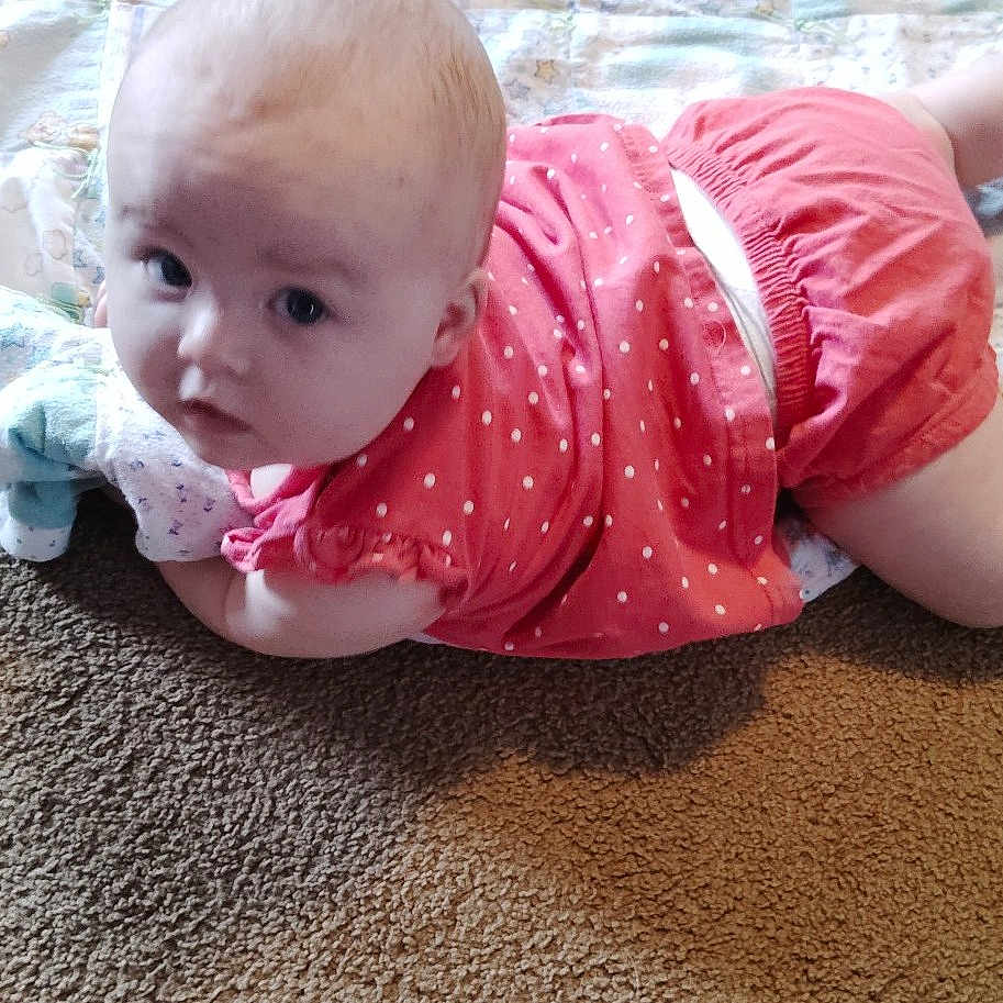Sadie Dawn is registered to the contest to win money with this photo: arms, baby, blanket, carpet, casual, child, comfortable, crawling, cute, floor, head, indoors, infant, legs, looking_up, pink_clothing, polka_dot, skin, soft_texture, young_child