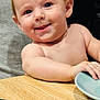 baby, child, smiling, tongue, table, plate, arm, skin, indoor, person, face, expression, happy, closeup, wood, blue, holding, casual, cute, young