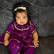 Airaa is registered to the contest to win money with this photo: baby, child, purple_clothing, headband, sitting, couch, indoor, portrait, cute, infant, happy, face, feet, hand, young_child, smiling, fashion, texture, cozy, decor