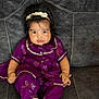 baby, child, purple_clothing, headband, sitting, couch, indoor, portrait, cute, infant, happy, face, feet, hand, young_child, smiling, fashion, texture, cozy, decor