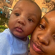 Ky Ky is registered to the contest to win money with this photo: baby, child, woman, portrait, close_up, outdoor, sunlight, face, expression, skin, clothing, building, tree, nature, daylight, person, head, young_child, curious, casual