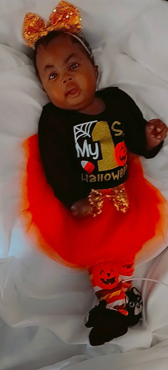 Cauri is registered to the contest to win money with this photo: arm, baby, baby_toddler_clothing, cheek, comfort, cool, elbow, event, fun, happy, head, human_body, neck, orange, person, red, sleeve, t_shirt, thigh, toddler