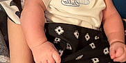Zayden joined the competition — help win amazing prizes! baby, infant, face, hand, blanket, clothing, patterned, white_shirt, cloud_design, arm, skin, cradling, holding, curious, portrait, indoor, closeup, cute, child, person