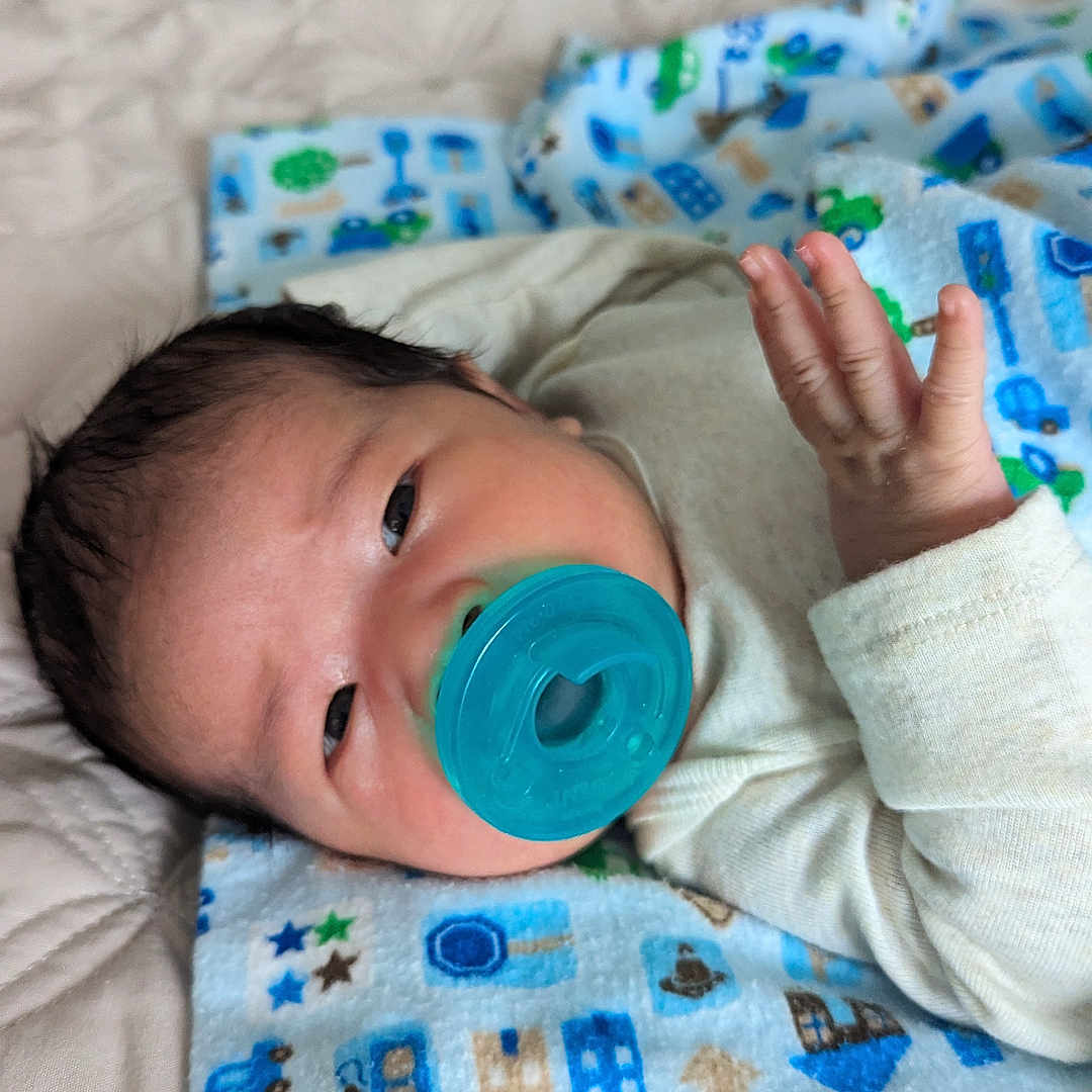 David joined the competition — help win amazing prizes! baby, bed, bedroom, blanket, bodypart, crib, cushion, face, finger, furniture, hand, head, homedecor, indoors, infantbed, newborn, person, photography, portrait, quilt