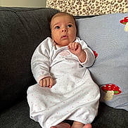 Elianna joined the competition — help win amazing prizes! baby, infant, couch, pillow, mushroom, white_clothing, foot, hand, face, eyes, indoor, cozy, sleeper, cute, child, expression, home, soft, seated, curious