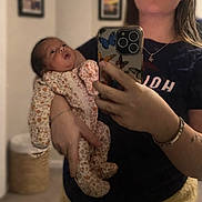 Melanie joined the competition — help win amazing prizes! baby, child, woman, mirror, selfie, phone, floral_clothing, indoor, portrait, person, holding, curious, casual_wear, bracelet, necklace, shorts, home, frame, photography, reflection