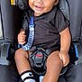 Tyce joined the competition — help win amazing prizes! baby, car_seat, smiling, child, black_clothing, socks, seatbelt, indoors, cute, happy, infant, safety, toddler, portrait, person, clothing, seat, black, young_child, baby_accessory