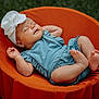baby, sleeping, infant, blue_romper, white_headband, flower_headband, orange_chair, outdoor, grass, peaceful, cute, child, portrait, relaxing, soft_light, summer, nature, small_feet, closed_eyes, resting