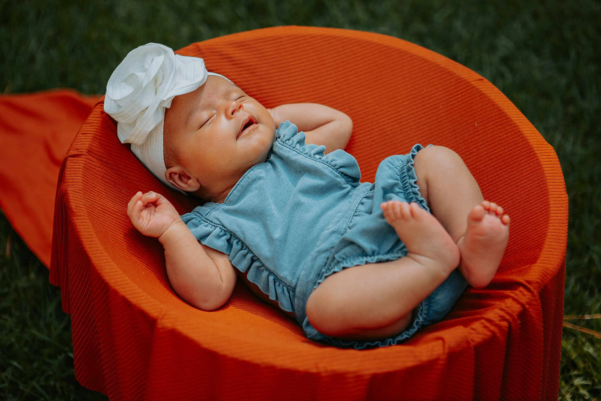 Lydia joined the competition — help win amazing prizes! baby, sleeping, infant, blue_romper, white_headband, flower_headband, orange_chair, outdoor, grass, peaceful, cute, child, portrait, relaxing, soft_light, summer, nature, small_feet, closed_eyes, resting