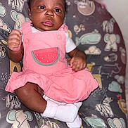 Jariyah joined the competition — help win amazing prizes! baby, infant, pink_dress, watermelon_patch, cushion, animal_print, elephant, sloth, zebra, whale, cloud, smiling_face, white_socks, dark_skin, curly_hair, indoor, portrait, child, cute, seated
