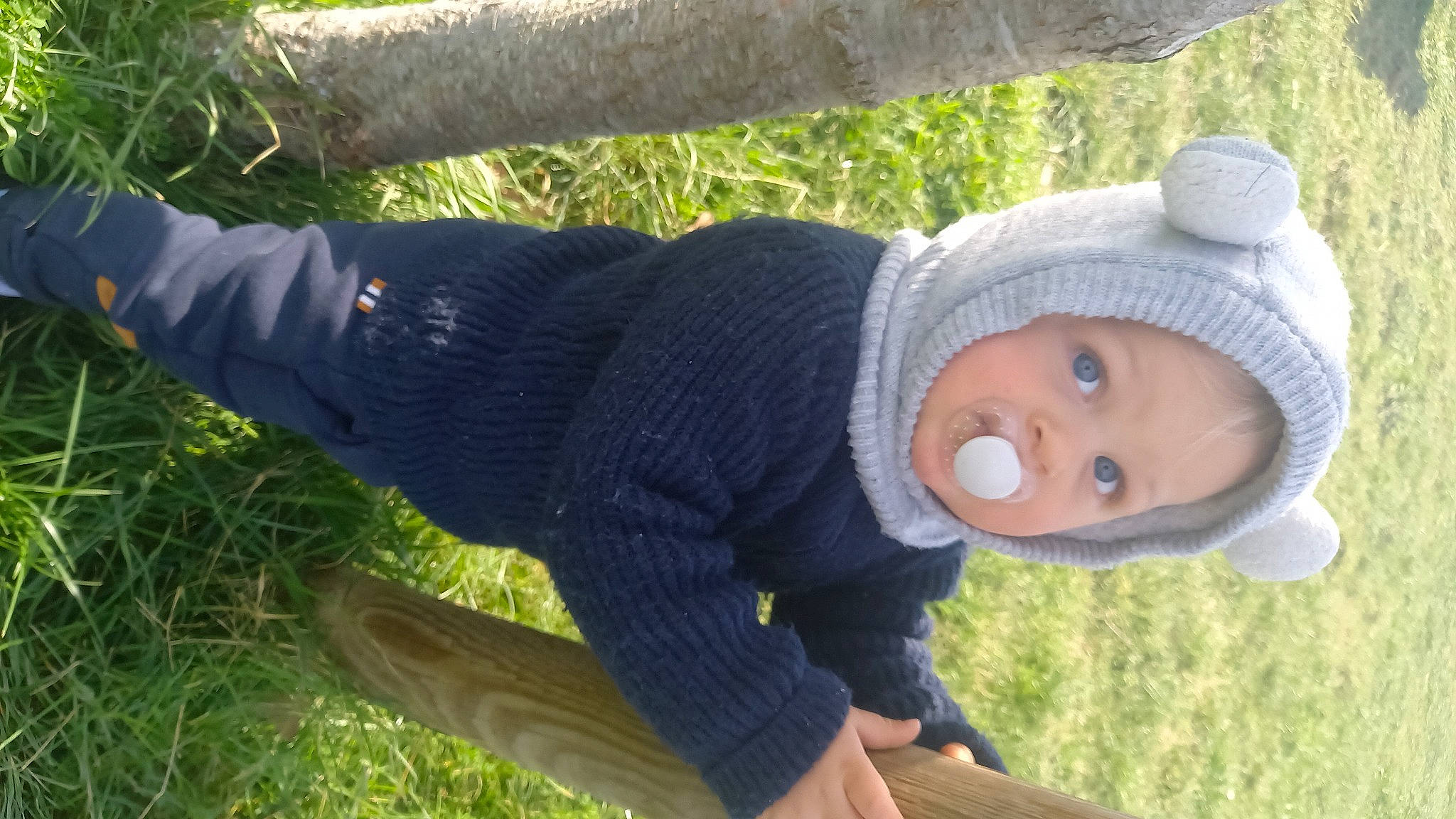 Luciano a rejoint le concours — aidez-le/la à gagner de superbes lots ! baby, baby_toddler_clothing, beanie, cap, grass, grass_family, grassland, happy, headgear, headwear, knit_cap, knitting, pattern, people_in_nature, person, plant, sitting, sleeve, toddler, tree