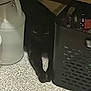 black_cat, cat, animal, pet, shadow, dark, container, basket, eyes, floor, indoor, quiet, hidden, curious, feline, mystery, still_life, household, quiet_moment, lurking
