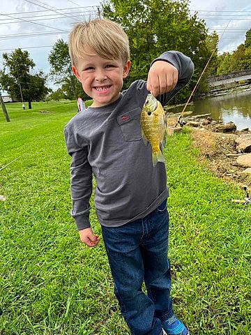 Bentley is registered to the contest to win money with this photo: child, cloud, fish, fun, gesture, grass, happy, joy, lake, leaf, leisure, people_in_nature, person, plant, recreation, sky, smile, sports_equipment, thumb, toddler