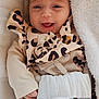 baby, infant, bow_headband, leopard_print, smile, smiling, cute, blanket, onesie, patterned_clothing, soft_toy, cozy, portrait, baby_face, hands, lying_down, crib, pillow, happy, fashionable