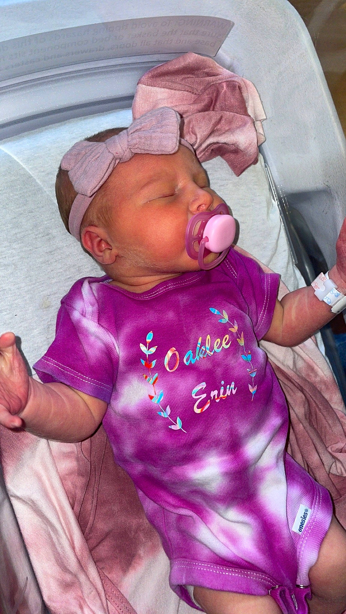 Oaklee is registered to the contest to win money with this photo: baby, baby_products, baby_toddler_clothing, cheek, child, comfort, happy, hat, headwear, lip, magenta, mouth, person, pink, purple, sitting, sleeve, t_shirt, toddler, violet