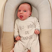 Lina a rejoint le concours — aidez-le/la à gagner de superbes lots ! baby, infant, onesie, baby_lounger, blanket, cushion, face, expression, tongue_out, clothing, soft_texture, indoor, child, newborn, person, sleepwear, cute, resting, comfort, portrait