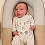 baby, infant, onesie, baby_lounger, blanket, cushion, face, expression, tongue_out, clothing, soft_texture, indoor, child, newborn, person, sleepwear, cute, resting, comfort, portrait