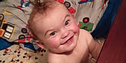 Jaxon joined the competition — help win amazing prizes! baby, child, smiling, crib, blanket, bedding, mohawk, nursery, wooden_rail, indoor, happy, cute, infant, person, playful, cartoon, colorful, fabric, bedroom, toddler