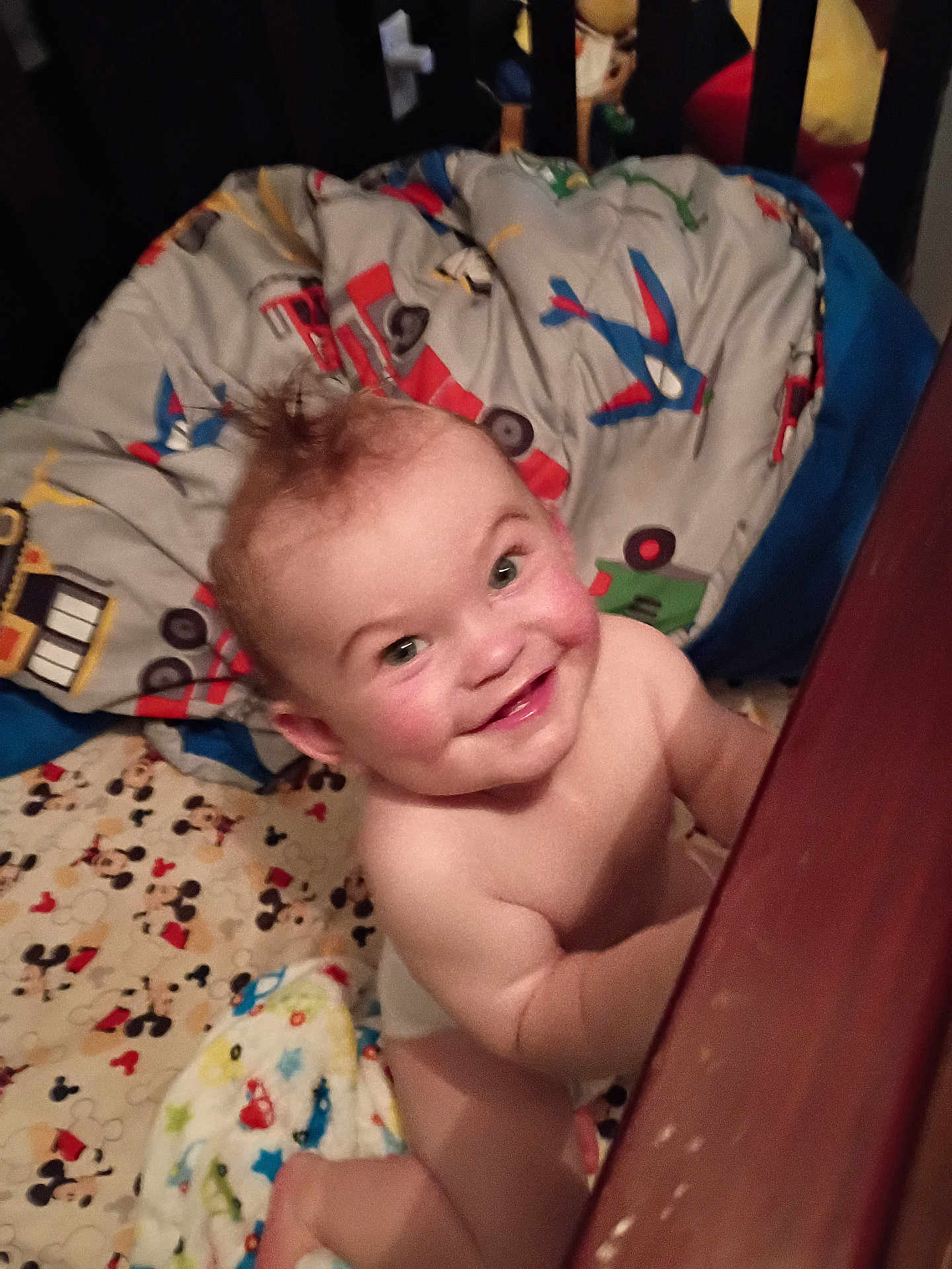 Jaxon joined the competition — help win amazing prizes! baby, child, smiling, crib, blanket, bedding, mohawk, nursery, wooden_rail, indoor, happy, cute, infant, person, playful, cartoon, colorful, fabric, bedroom, toddler