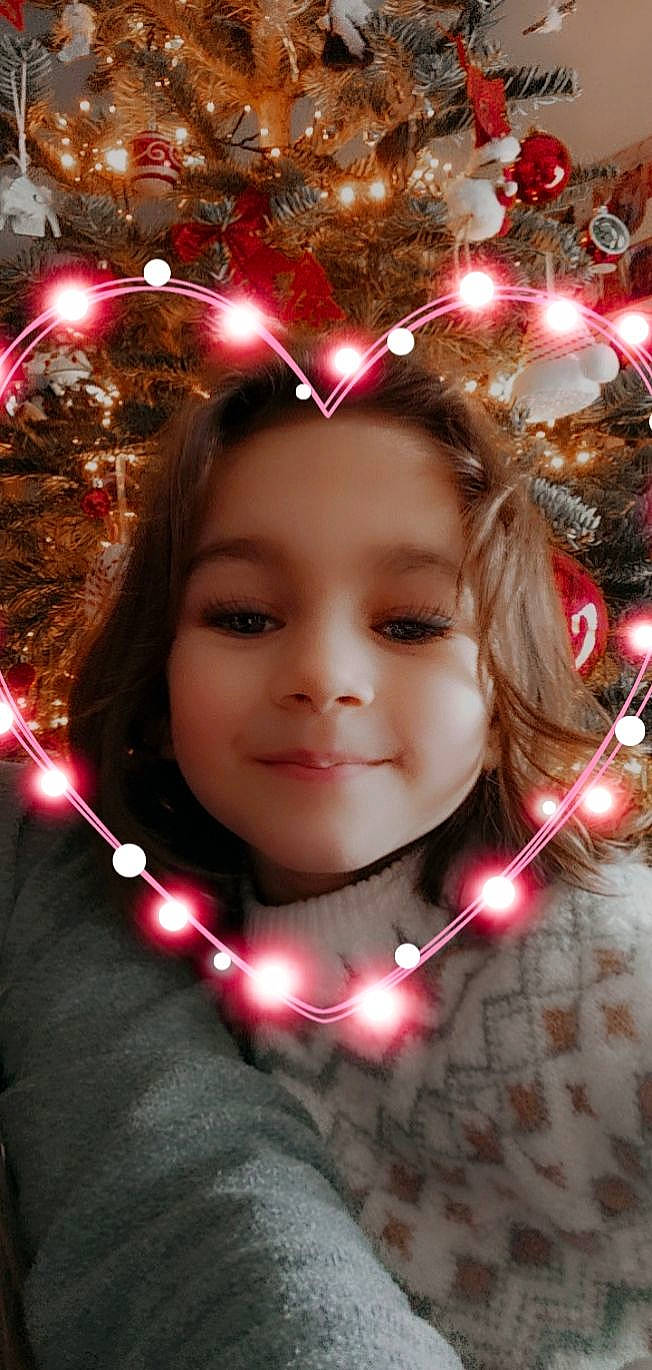 Neyla a rejoint le concours — aidez-le/la à gagner de superbes lots ! branch, chin, christmas_ornament, christmas_tree, eye, face, facial_expression, hair, hairstyle, happy, head, holiday_ornament, human_body, joy, light, lighting, person, plant, smile, standing