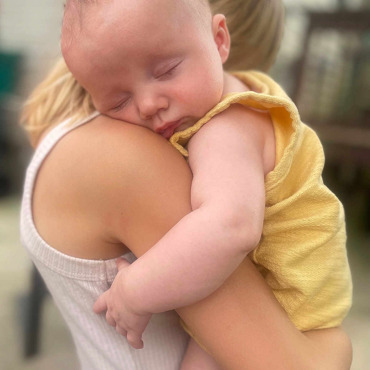 Kade is registered to the contest to win money with this photo: baby, infant, sleeping, child, 抱抱, cuddle, shoulder, yellow_outfit, white_shirt, blonde_hair, portrait, indoor, soft_lighting, close_up, family, affection, peaceful, arms, hand, purple_nail_polish