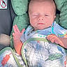 newborn, baby, infant, sleeping, sleepy, face, portrait, car_seat, blanket, swaddled, onesie, clothing, raised_hand, hands, indoors, vehicle, soft_blanket, pastel_colors, close_up, safe
