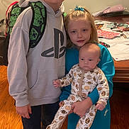 Kade joined the competition — help win amazing prizes! children, siblings, baby, boy, girl, infant, portrait, family, indoors, smiling, glasses, hoodie, backpack, pajamas, holding_baby, standing, sitting, desk, wooden_floor, home