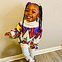 baby, babylaughing, braid, child, clothing, cornrows, face, female, footwear, girl, hair, happy, head, person, shoe, sitting, sleeve, smile, standing, student