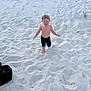 child, toddler, beach, sand, barefoot, shorts, smile, happy, outdoors, summer, footprints, dune_grass, bag, play, vacation, sunny, portrait, small_person, sand_patterns, coastal