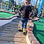 Grayson joined the competition — help win amazing prizes! batman_boots, blue_sky, boots, brick_border, child, clouds, green_turf, jeans, kid, leisure, mini_golf, outdoor, palm_trees, portrait, putter, shadow, sunglasses, toy_course, tshirt, wooden_deck