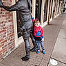 Grayson joined the competition — help win amazing prizes! child, statue, sidewalk, brick_wall, building, storefront, window, shoe, hoodie, camo_pants, playful, outdoor, urban, casual_clothing, boy, public_art, street, pose, daytime, smile