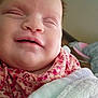 Dollyne is registered to the contest to win money with this photo: baby, smiling, close_up, face, infant, child, blanket, clothing, pink, floral, soft, cute, happy, indoors, sleepy, person, skin, head, chubby, newborn