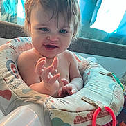 Kylon is registered to the contest to win money with this photo: baby, baby_seat, child, colorful, curtain, cute, diaper, face, hands, happy, home, indoor, infant, person, playtime, seat, smiling, soft_light, toy, young_child