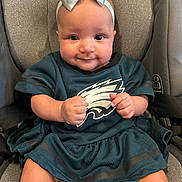 Layla Rose is registered to the contest to win money with this photo: baby, infant, child, car_seat, headband, bow, sportswear, teal_dress, smile, fists, cute, portrait, indoors, seat_belt, young_child, happy, person, clothing, apparel, closeup