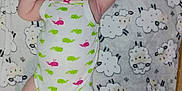 Calena is registered to the contest to win money with this photo: baby, infant, child, onesie, pink_bow, headband, blanket, sheep_pattern, lying_down, cute, arms_up, curious, indoors, soft_texture, sleepwear, white_clothing, green_whales, pink_whales, portrait, human