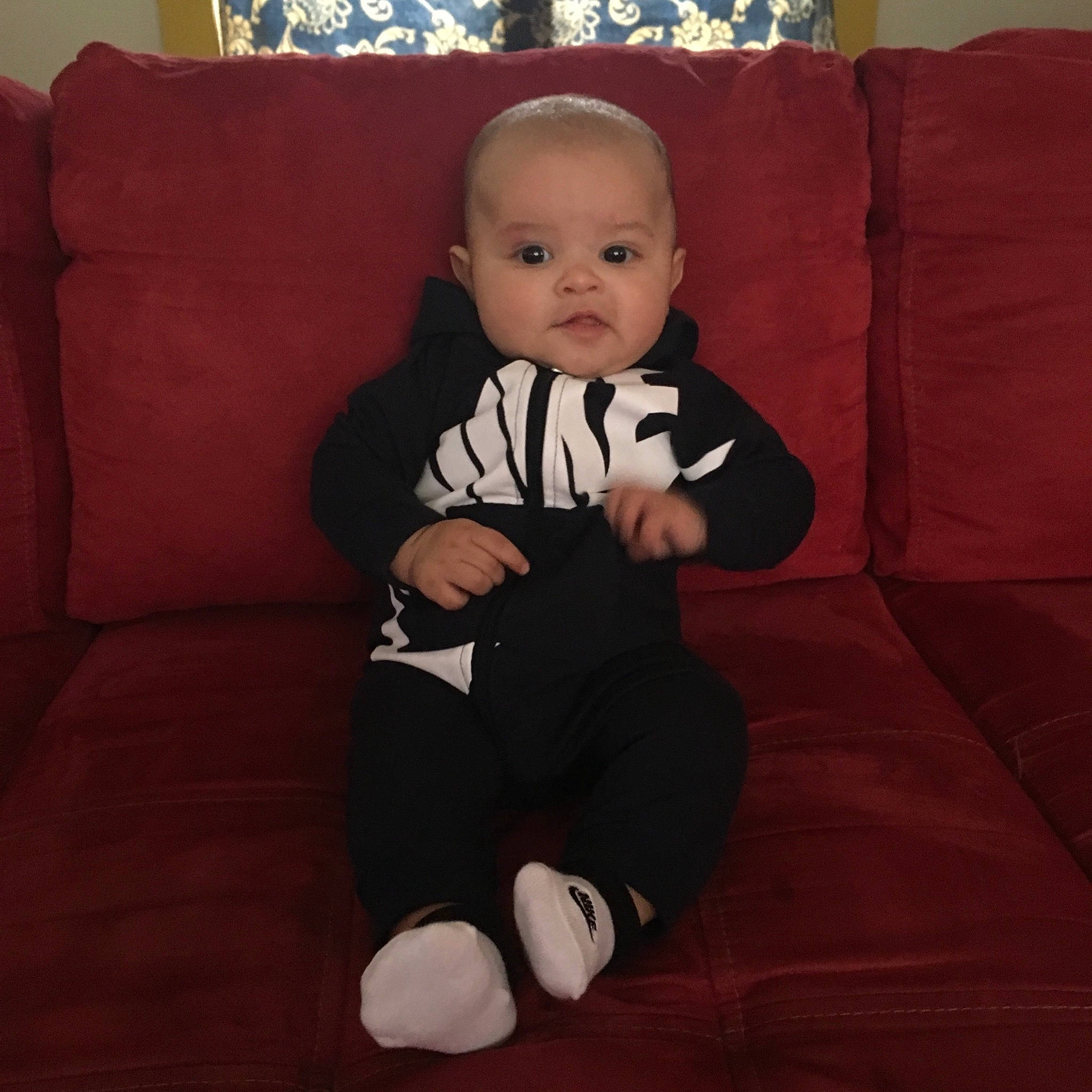 Kenai is registered to the contest to win money with this photo: baby, baby_toddler_clothing, cheek, child, flooring, head, leg, person, shoe, sitting, sleeve, toddler