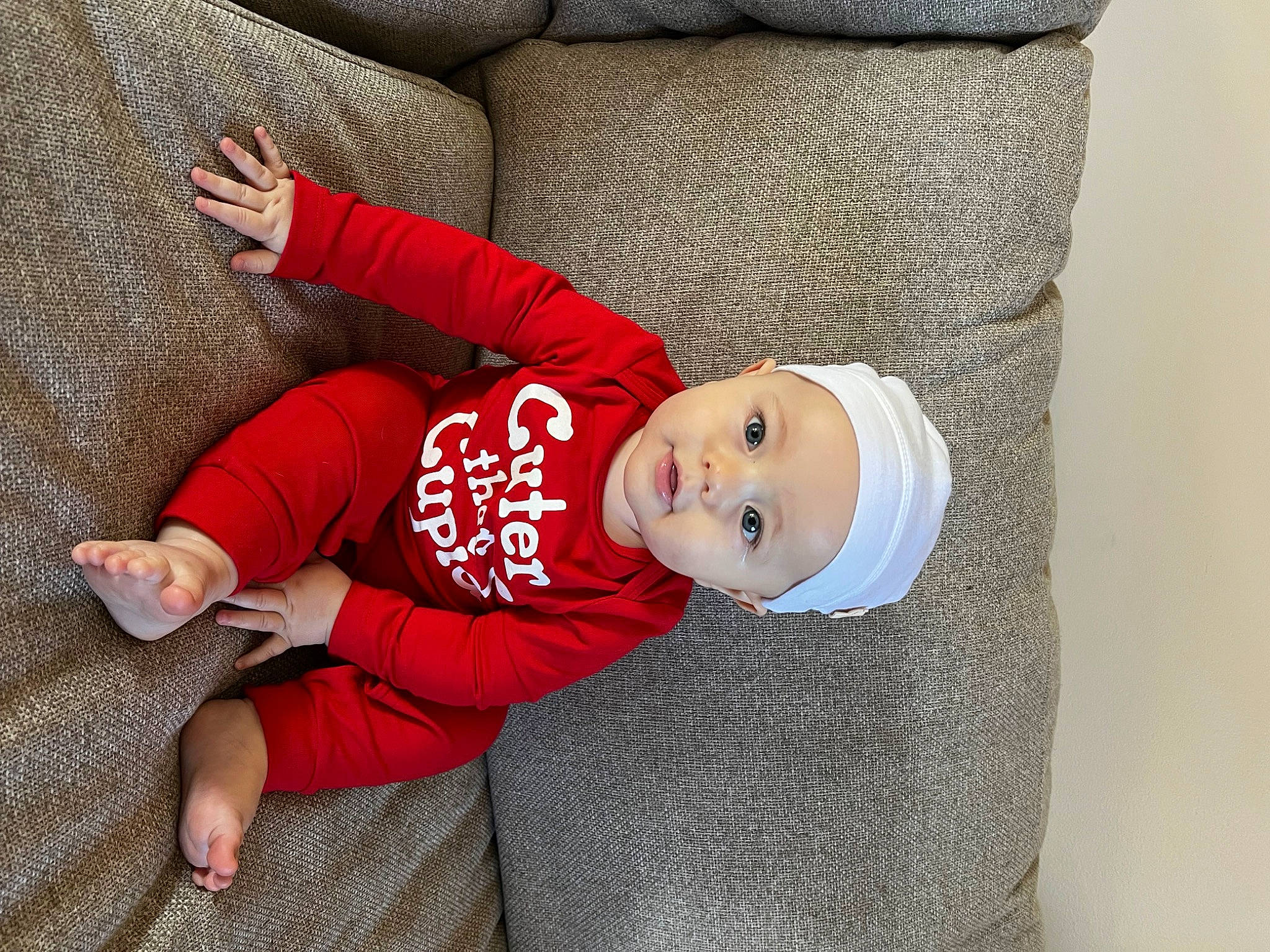 Winon is registered to the contest to win money with this photo: baby, baby_toddler_clothing, carmine, child, comfort, face, grass, happy, hat, headwear, human_leg, knee, pattern, person, sitting, sleeve, smile, sock, t_shirt, toddler
