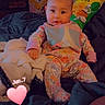 Freydis Griffin is registered to the contest to win money with this photo: baby, child, pajamas, blanket, bed, pillow, chips, curtain, cartoon, face, sitting, indoors, cozy, cute, colorful, person, clothing, expression, soft, relaxing