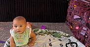 Freydis Griffin joined the competition — help win amazing prizes! baby, infant, milestone_blanket, months, floor, carpet, couch, blanket, toy, home, child, indoor, face, cute, smiling, clothing, bib, sitting, heart_effects, decor