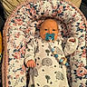 baby, infant, pacifier, onesie, elephant_print, floral_pattern, cushion, blanket, sleeping_bed, child, cute, cozy, indoors, newborn, person, portrait, resting, soft_toys, pink, white