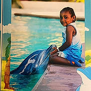 Carson is registered to the contest to win money with this photo: child, dolphin, water, pool, smile, outdoor, person, animal, marine_life, dock, blue_clothing, shorts, tank_top, cute, friendship, summer, sunlight, playing, nature, happy