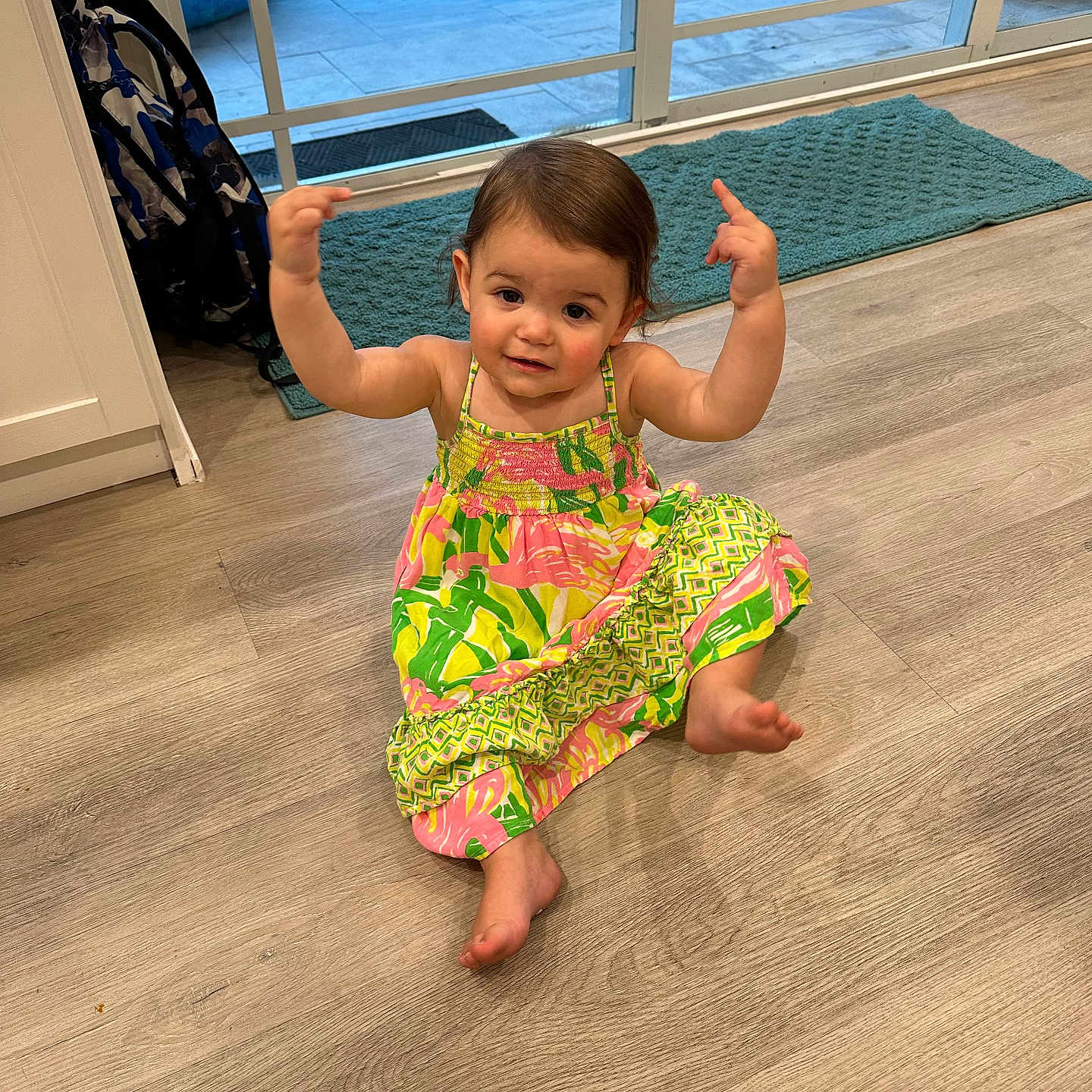 Harper is registered to the contest to win money with this photo: baby, barefoot, clothing, door, dress, face, footwear, hardwood, head, pants, person, photography, plant, pool, portrait, pottedplant, sandal, sitting, water, wood