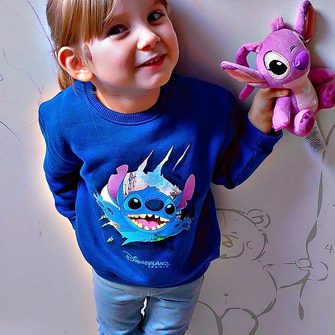 Keyla Claine participe au concours pour gagner de l'argent avec cette photo : balloon_drawing, black_shoes, blue_sweatshirt, casual_clothing, child, cute, door, drawing, happy, indoor, jeans, person, plush_toy, portrait, round_handles, smiling, stitch_character, teddy_bear_drawing, wooden_floor, young_child