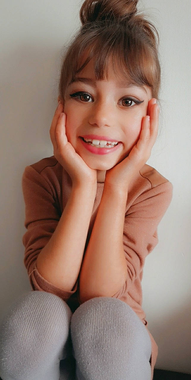 Oceane a rejoint le concours — aidez-le/la à gagner de superbes lots ! beauty, brown_hair, cheek, child_model, chin, eyebrow, face, facial_expression, gesture, hair, jaw, joy, lip, model, person, sitting, skin, smile