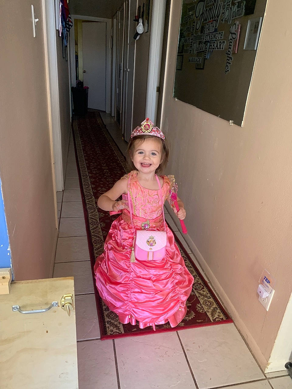 Emilia is registered to the contest to win money with this photo: baby_toddler_clothing, child, costume, day_dress, door, fashion_design, floor, flooring, fun, hardwood, hat, joy, magenta, one_piece_garment, pattern, person, pink, room, sleeve, smile